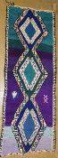 A vintage Moroccan Azilal runner, the triple pole medallion on a vibrant ground of turquoise, purple