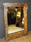 A Georgian design ornately carved giltwood and silvered wall mirror with large rectangular plate,