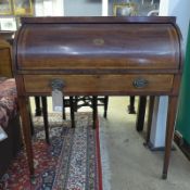 A George III inlaid mahogany cylinder writing desk with fitted interior above frieze drawer on