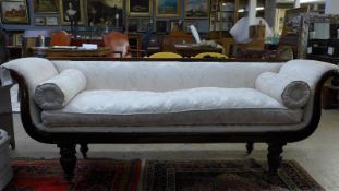 An early 19th Century Regency mahogany sofa, the floral damask upholstery within scrolled