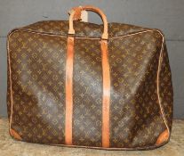 A designer Louis Vuitton leather travelling suitcase, having all over typical design 63cm x 52cm