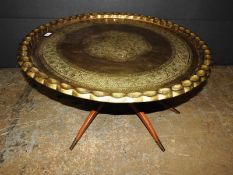 An Islamic Benares design brass low table, the floral decorated tray top over splayed teak supports,