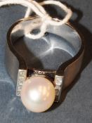 An 18ct gold ring with a large central pearl and baguette cut diamonds, stamped '18k' (14.3g)