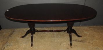 A 1950s Italian designer mahogany dining table in the manner of Paolo Buffa, the solid oval top