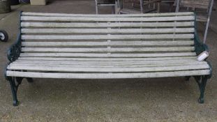 A Victorian design painted scroll back wooden garden bench with cast iron end supports 188cm x