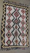 A vintage Moroccan Ourika rug, the all over polychromatic diamond design on an ivory ground within a