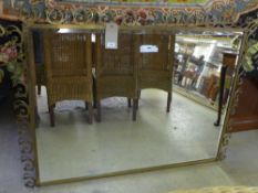 A large early/mid 20th Century French mirror, the swirling brass frame centred with a bevelled plate