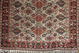 A Persian Zanjan Souzzani rug, the repeating foliate design on a scarlet ground within a