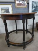 A Cotswold School oak centre table, the circular top on stretcher turned supports, 92cm x 76cm
