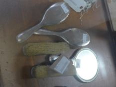 An Arts and Crafts silver five piece dressing table set, comprising hand mirror and four brushes