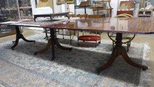An early 19th Century George III mahogany triple pillar dining table, the figured top over later