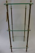 A 20th Century three tiered brass and glass etagere, having acorn finials, 83cm x 35cm