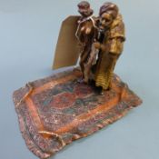 A Franz Bergman cold painted bronze figure group of a carpet seller with nude figure beside standing