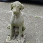 A stone garden sculpture of a sitting dog with puppies