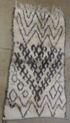 A vintage Moroccan Azilal rug, the all over abstract design on an abrashed ivory ground 190cm x