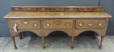 An 18th Century George I oak dresser base, the gallery back having three short drawers over three