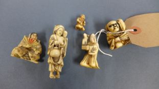 An ivory netsuke of a crouching man with a fan and four other netsuke (5)