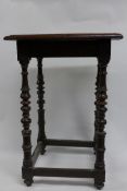 An early 18th Century English walnut occasional table, the figured square top over ornately turned