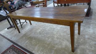 A late 19th Century French fruitwood farmhouse table, the plank top over square tapered supports