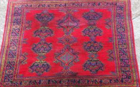 An antique Turkish Oushak carpet, the all over tyical design on a scarlet ground within multiple