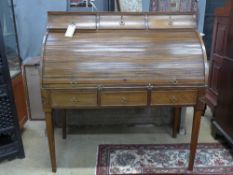 An early 19th Century George III mahogany roll top desk having three drawers over tambour front