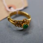 An 18k gold ring, diamond chips with central circular emerald stone
