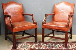 A pair of Georgian design Gainsborough style open armchairs, the studded tanned leather upholstery