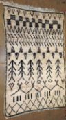 A vintage Moroccan Azilal rug, the all over Berber motif design on an ivory ground 225cm x 140cm