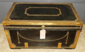 An early 20th Century brass studded black leather clad trunk with twin handles, 85cm x 55cm