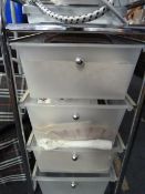Chrome bathroom cabinet containing assorted towels, etc