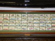 Framed collection of cigarette cards depicting motor vehicles throughout the ages