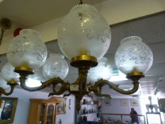 Brass five branch chandelier with frosted glass shades