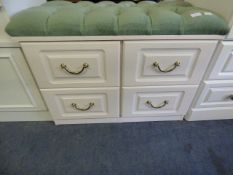 White chest of four drawers with upholstered top