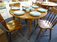 Medium oak circular dining table with four spindle back chairs