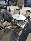 *CIRCULAR METAL TABLE WITH GLASS TOP PARASOL AND FOUR RECLINING CHAIRS
