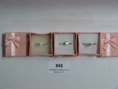 THREE SILVER METAL DRESS RINGS WITH INSET STONES