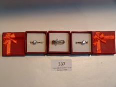 THREE SILVER METAL DRESS RINGS WITH INSET STONES