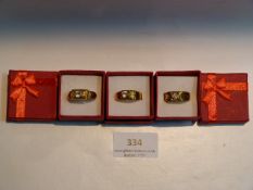 THREE GOLD METAL DRESS RINGS WITH INSET STONES