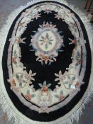 Oval Black and Floral Patterned Rug