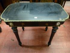 An Edwardian ebonized side table with cast brass edging and embellishments, shaped top over a single