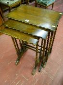 A nest of three oak wavy top side tables with barley twist supports, 68 cms high, 50 cms wide, 32