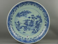 A large 19th Century Chinese deep dish charger, blue and white scroll pattern decoration with