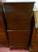 A reproduction crossbanded mahogany one piece chest on chest having six drawers with brass ring