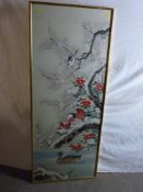 A large Oriental painted panel of birds amongst snowy blossom filled branches, mounted behind