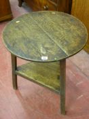 A 19th Century oak cricket table, the 54.5 cms diameter top on chamfered legs with triangular