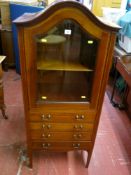 An Edwardian inlaid mahogany dome topped cabinet with bevelled glass door and interior shelf over