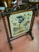 A Victorian mahogany barley twist firescreen with embroidered panel of flowers and animals, open