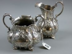 An electroplated twin handled sugar basin and cream jug each with raised and scroll decoration and