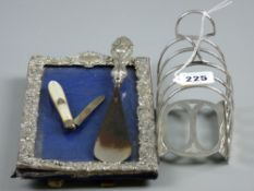 An embossed silver photograph frame, 21.5 x 13 cms, a silver and mother of pearl fruit knife, a