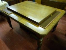 A circa 1900 oak extending dining table with canted corners and two extra leaves on block and turned